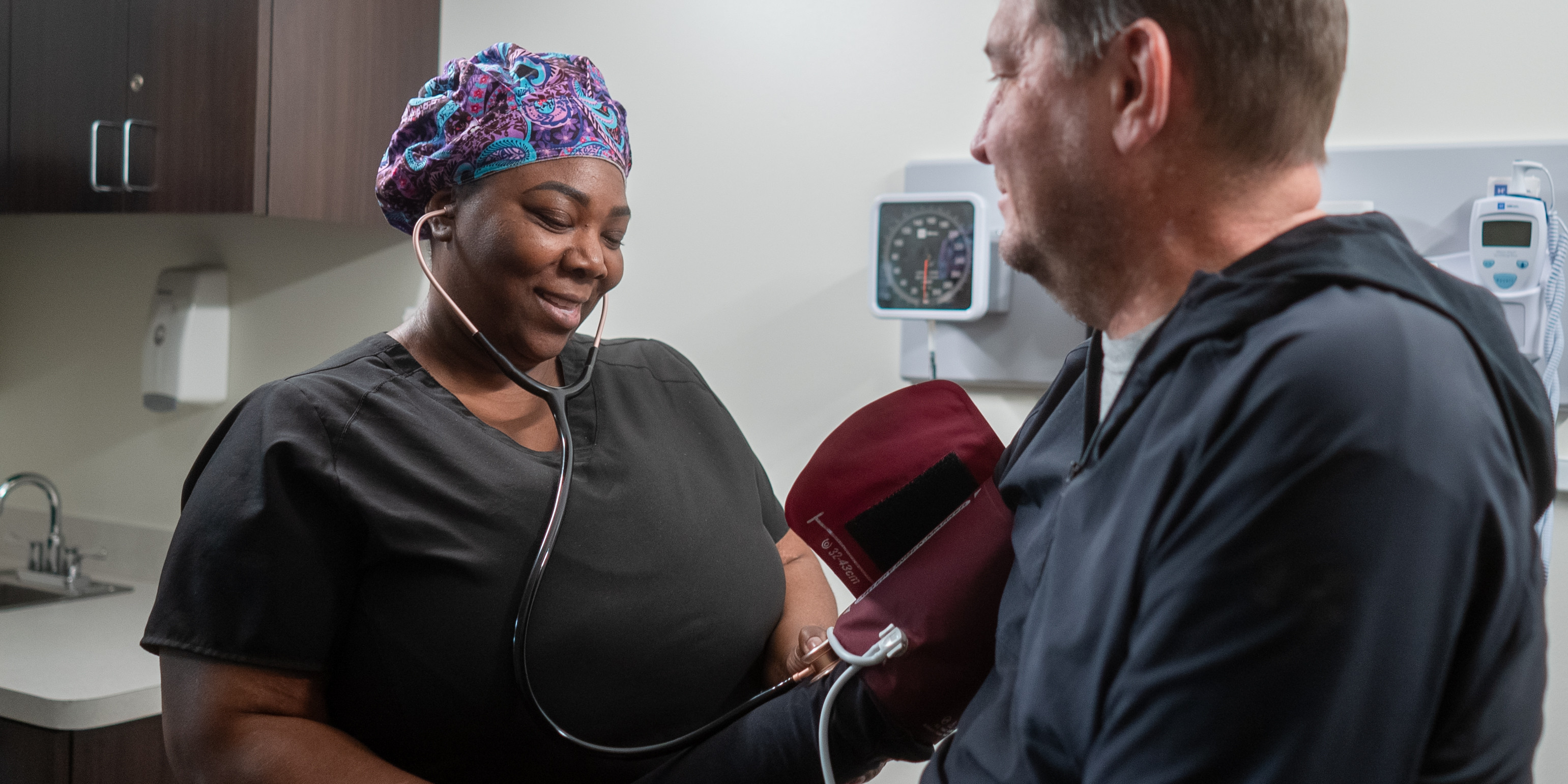 a nurse checks a patient's blood pressure.
