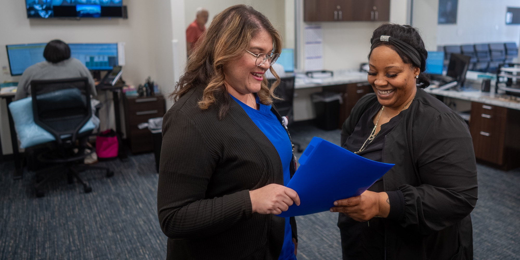 two healthcare workers looking at a file