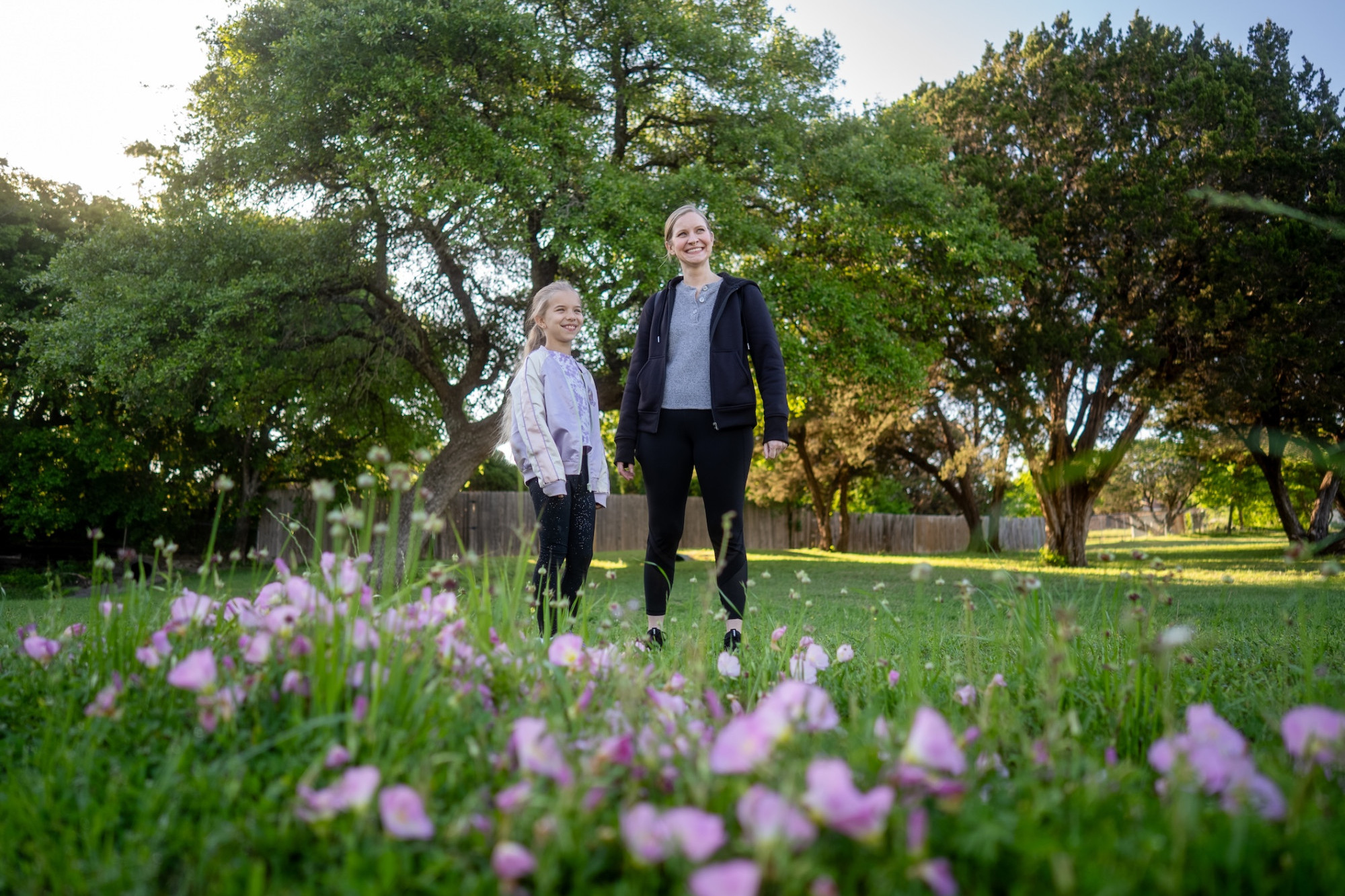 woman and child in athletic wear in a field of flowers