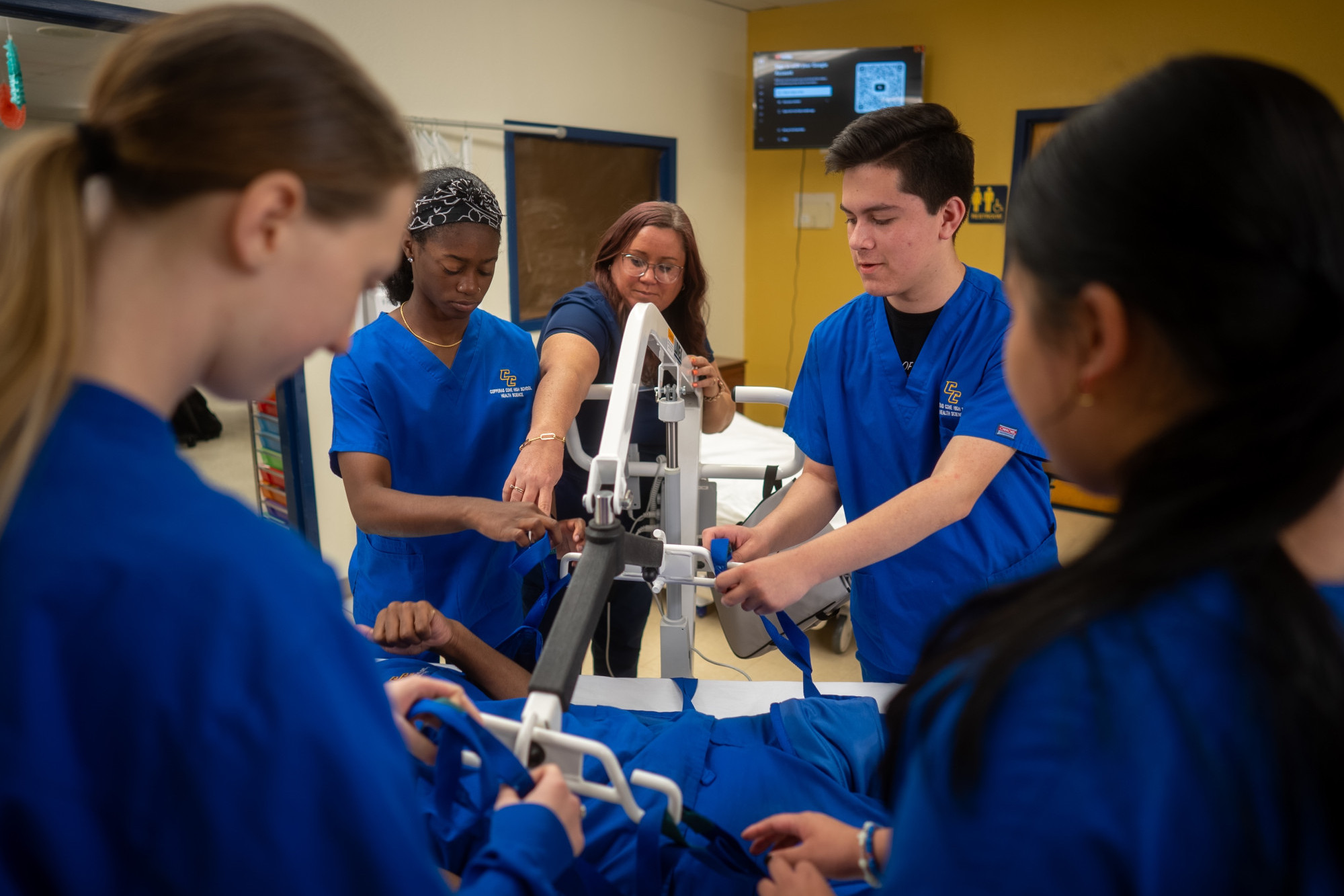 a group of nursing students work with medical equipment